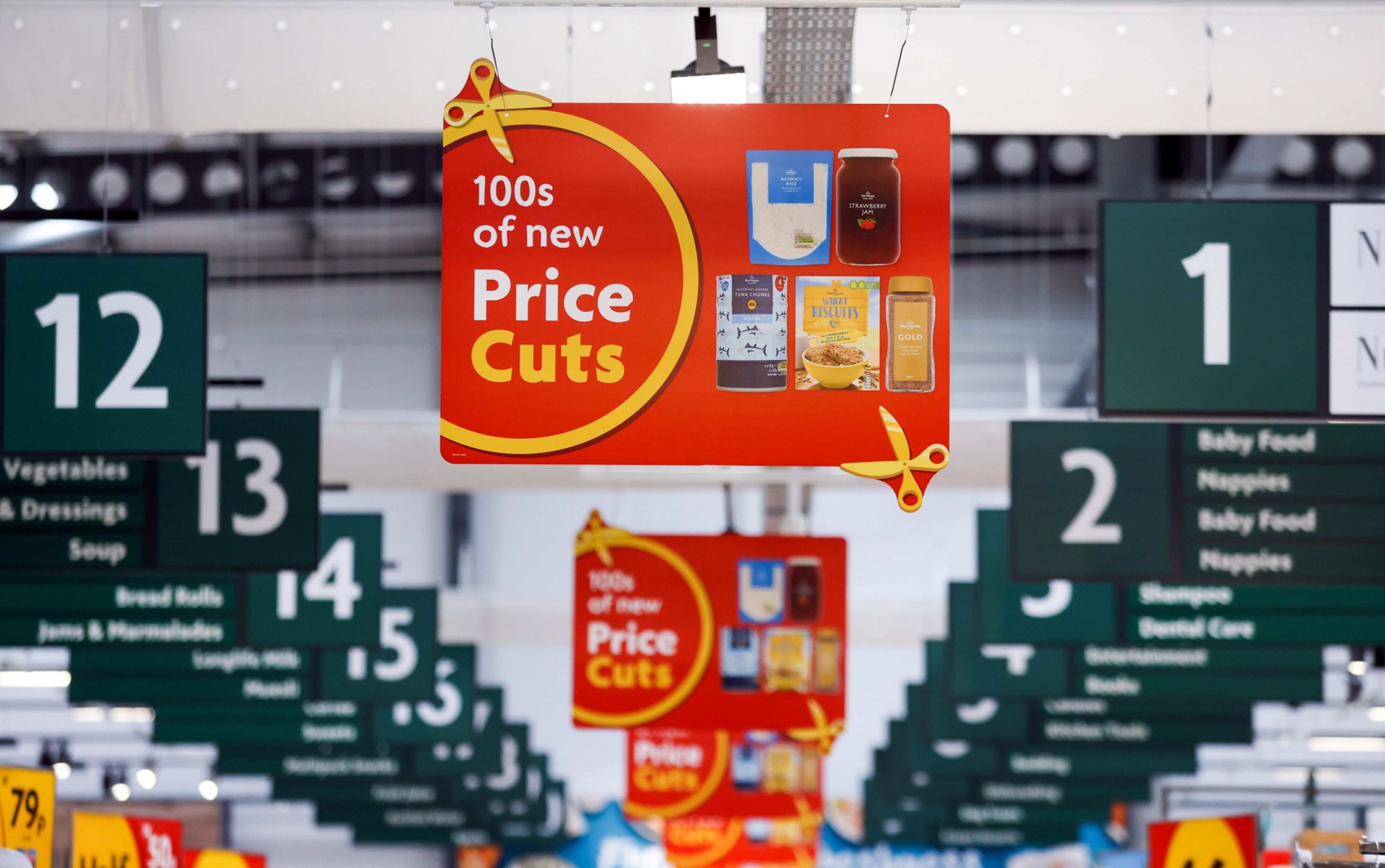 Signs advertising price cuts in a Morrisons supermarket. Photographer: Chris Ratcliffe/Bloomberg